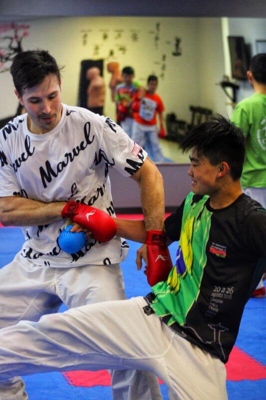 Sensei Alejandro Rodríguez: a professional athlete and karateka instructing one of his students in the Kazoku Karate dojo - Greenville, South Carolina - Martial arts club in SC, USA
